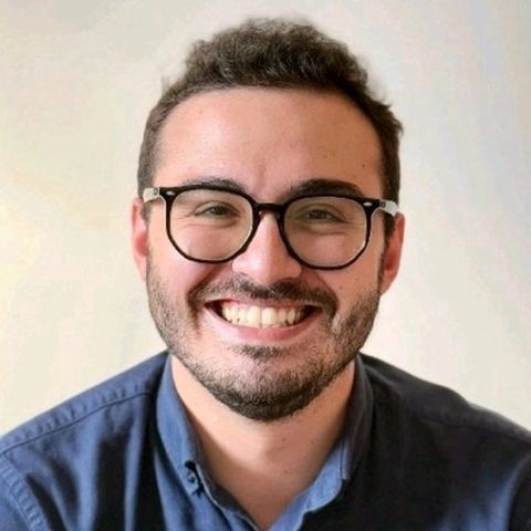 Artur Batissoco, fundador do MuralFreela, sorrindo, de óculos e camisa azul